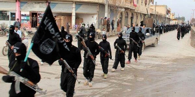 ISIS fighters march in the streets of their former caliphate' in Raqqa, Syria. 