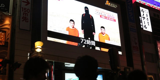 A TV news program reports two Japanese hostages held by the Islamic State group in Tokyo, Friday, Jan. 23, 2015. Militants affiliated with the Islamic State group have posted an online warning that the "countdown has begun" for the group to kill a pair of Japanese hostages. (AP Photo/Eugene Hoshiko)