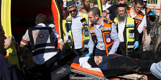 Israeli medics move a handcuffed Palestinian woman, who police believe attacked a man, at the scene of a stabbing attack in Jerusalem, Monday, Nov. 23, 2015. (AP Photo/Sebastian Scheiner)