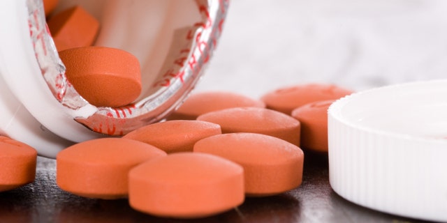 Over the counter medication on black table with bottle and cap