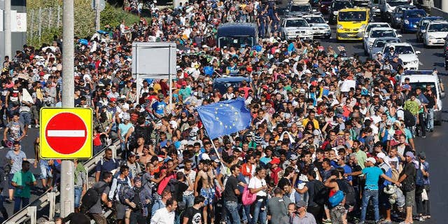 FILE - In this Friday Sept. 4, 2015 file photo, migrants walk out of Budapest, Hungary. As much of Europe hesitates, Iceland, which has just in recent years emerged from the effects of a devastating economic meltdown, seems to be warming to the idea of taking in Syrians fleeing their war-torn homeland. It’s a historic shift for an island that has long been reluctant to take in foreigners. (AP Photo/Frank Augstein, File)