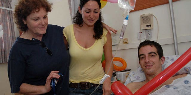 In this photo taken on Aug. 3, 2006, Israeli, U.S-born, Ilan Grapel, right, pauses for a photographer as he is hospitalized after he was injured during the Israel Lebanon war at the Rambam hospital in the northern Israeli city of Haifa.