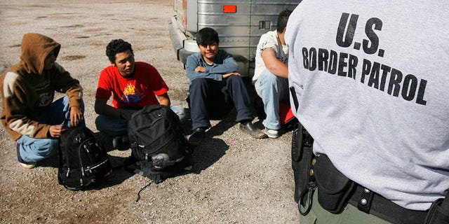 Jan. 19, 2007 file photo, the U.S. Border Patrol detains a large group of suspected immigrants at the Arizona-Mexico border in Sasabe, Ariz.