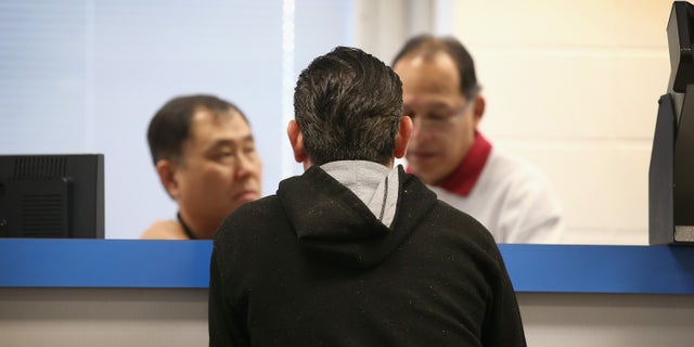 CHICAGO, IL - DECEMBER 10: Abel Hernandez (C) applies for a Temporary Visitors Driver's License (TVDL) at a driver services facility on December 10, 2013 in Chicago, Illinois. Illinois recently began the TVDL program which will allow undocumented immigrants to obtain driver's licenses. The applicants must have an Illinois address, prove 12 months of residency in the state, and have a valid passport or consular card to be eligible. (Photo by Scott Olson/Getty Images)