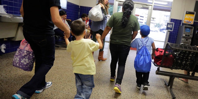 FILE - In this July 7, 2015, file photo, immigrants from El Salvador who entered the country illegally walk through a bus after they were released from a family detention center in San Antonio. With tens of thousands of Central American families arriving on the U.S.-Mexico border in the last two years, federal authorities have crafted a new plan to try to encourage more of them to show up for immigration court. Starting on Thursday, Jan. 21, 2016, as many as 800 families who pass an initial asylum screening can join the program in Los Angeles, New York, Washington, Chicago and Miami. Case workers will be assigned to help them with daily tasks such as finding transportation to immigration court and enrolling their children in school. (AP Photo/Eric Gay, File)