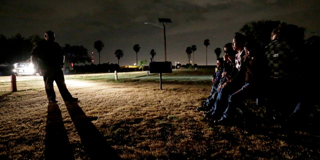 FILE - In this June 25, 2014, file photo, a group of immigrants from Honduras and El Salvador, who crossed the U.S.-Mexico border illegally, are stopped in Granjeno, Texas. The Homeland Security Department is experimenting with a new way to track immigrant families caught crossing into the U.S. illegally then released: GPS-enabled ankle bracelets. (AP Photo/Eric Gay, File)