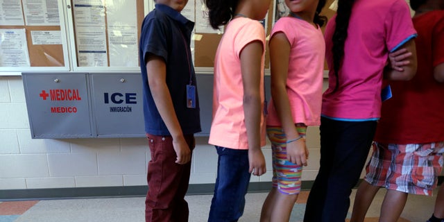 Detained immigrant children line up in a cafeteria at a temporary home in Karnes City, Texas.