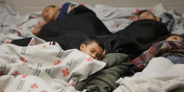 Kids sleep in a holding cell at a U.S. Customs and Border Protection facility, June 18, 2014, in Brownsville,Texas.