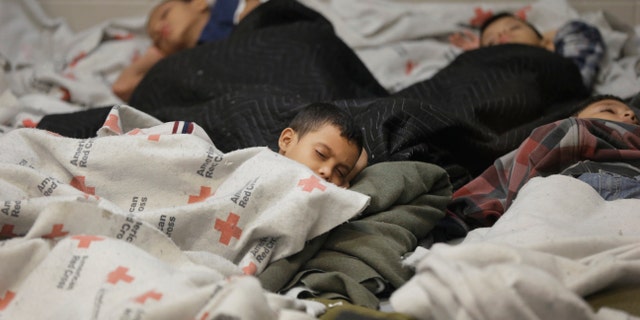 Kids sleep in a holding cell at a U.S. Customs and Border Protection facility, June 18, 2014, in Brownsville,Texas.