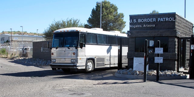 June 7, 2014: A bus leaves the entrance of the U. S. Border Patrol facility in Nogales, Ariz. Arizona officials said they are rushing federal supplies to this makeshift holding center in the southern part of the state that's housing hundreds of migrant children and is running low on the basics. (AP Photo/Brian Skoloff)
