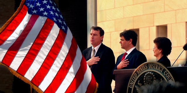 FILE - In this Nov. 14, 2005 file photo, U.S. Southern District Judge Andrew S. Hanen, left, joins with Filemon B. Vela, Jr. and Blanca Vela for the Pledge of Allegiance during the United States Courthouse naming ceremony in Brownsville, Texas. Hanen's move to block President Barack Obamaâs orders on immigration lays bare a pervasive but not widely known practice in federal district courts: venue shopping. Immigration advocates say that lawyers for the state of Texas were seeking a court with sympathetic judges when they filed their case in Brownsville. (AP Photo/The Brownsville Herald, Brad Doherty, File)