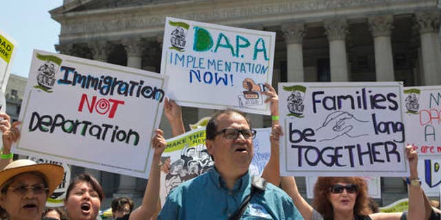 FILE - In this June 24, 2016, file photo, demonstrators protest against a Supreme Court decision on immigration outside the New York Supreme court in New York. The future of millions of people living in the U.S. illegally could well be shaped by the presidential election. The stakes are high, too, for those who employ them, help them fit into neighborhoods, or want them gone. (AP Photo/Mary Altaffer, File)