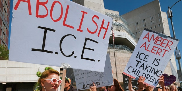 Protesters carry signs during a rally in front of the Immigration and Customs Enforcement facility in downtown Los Angeles on Monday, July 2, 2018.