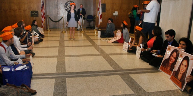 At center, Evelyn Rivera, a student at Valencia College in Orlando, Fla., speaks to students participating in a "Dream University" sit-in Thursday April 24, 2014, outside the Senate on the fourth floor of the Capitol in Tallahassee, Fla. The students are urging legislators to pass the in-state tuition bill, Senate Bill 1400 - Postsecondary Student Tuition. The bill is currently being held up in the Senate. (AP Photo/Phil Sears)