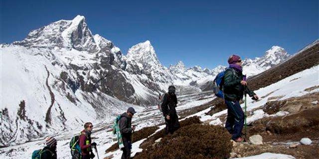 In this March 18, 2015, file photo, trekkers take an acclimatization hike on the way to Everest base camp in Nepal.