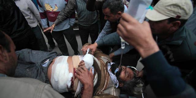 An injured man is carried on a stretcher for treatment to the Government Medical College after an attack in Jammu, India, Friday, March 28, 2014. One person was killed and three others injured Friday when unidentified gunmen wearing army uniform stopped a vehicle on the Jammu-Pathankot National Highway and shot its occupants, police said. The gunmen later escaped in the same vehicle. (AP Photo/Channi Anand)