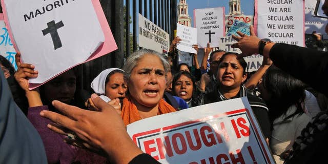 Indian Christians hold placards protesting against attacks on churches in the Indian capital as they assemble outside the Sacred Heart Church in New Delhi, India.