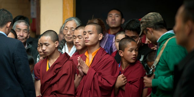 Oct. 31, 2012: Tibetan Buddhist monks wait to greet their spiritual leader the Dalai Lama, unseen, during a religious talk at the Tsuglakhang temple in Dharmsala, India.