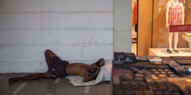 May 27, 2015: An Indian homeless man sleeps on a pavement in a market area on a hot summer day in New Delhi. In southern India, hundreds of people have died since the middle of April as soaring summer temperatures scorch the country, officials said Tuesday. (AP Photo/Tsering Topgyal)