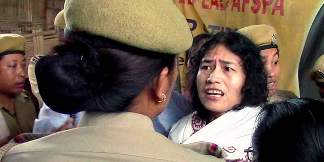 In this Friday, Aug. 22, 2014 photo, Irom Sharmila is detained by policewomen in Imphal, in the northeastern Indian state of Manipur. The frail Indian activist who has been on a hunger strike for nearly 14 years to protest alleged military brutality scuffled with police Friday as they took her back to the same government hospital where she had been force-fed. Sharmila, 42, vowed to continue the hunger strike that landed her in prison for the past 14 years. She walked free on Wednesday after a court threw out the charges of attempted suicide against her. Attempted suicide is a crime in India. (AP Photo/Press Trust of India) INDIA OUT