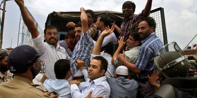 Indian policemen detain Jammu Kashmir state government employees as they shout slogans during a protest in Srinagar, India, Monday, July 18, 2011. The employees demanded payment of arrears in salaries, raising of retirement age and other demands.