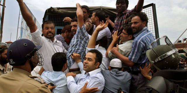 Indian policemen detain Jammu Kashmir state government employees as they shout slogans during a protest in Srinagar, India, Monday, July 18, 2011. The employees demanded payment of arrears in salaries, raising of retirement age and other demands.