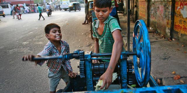 Ravi, 8, left, and Guddu, 12, extract sugarcane juice, in Gauhati, India, Friday, Oct. 10, 2014. Malala Yousafzai of Pakistan and Kailash Satyarthi of India won the Nobel Peace Prize on Friday, Oct. 10, 2014, for risking their lives to fight for children’s rights. (AP Photo/Anupam Nath)