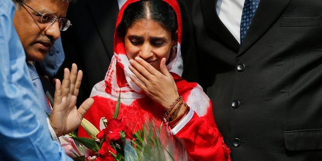 Oct. 26, 2015: Geeta, 23, center, a deaf and mute Indian woman who accidentally strayed into Pakistan as a child 12 years ago, arrives at the airport in New Delhi. (AP Photo /Tsering Topgyal)