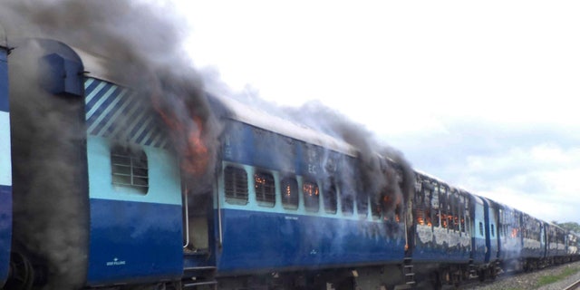 Aug.19, 2013 - Coaches of the Rajya Rani Express train burn after a mob set it on fire as it ran over a group of Hindu pilgrims at a crowded station in Dhamara Ghat, Bihar state, India. At least 37 people were killed.