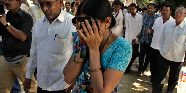 Nov. 9, 2011: An unidentified relative of one of the convicted Hindus breaks down upon hearing the verdict at the district court in Mehsana, about 25 miles north of Ahmadabad, India.