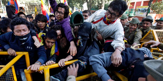 Feb. 8, 2012: Tibetan exiles shout slogans as they attempt to break a police barricade near the Chinese Embassy at a protest against the Chinese government, in New Delhi, India.