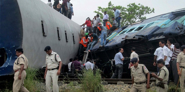 May 26, 2014: Indian officials and rescuers gather around the wreckage after the Gorakhpur Express passenger train slammed into a parked freight train Chureb, near Basti, Uttar Pradesh state, India. (AP)