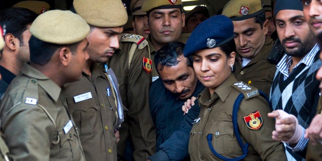 Dec. 8, 2014: Shiv Kumar Yadav, center, a driver from the international taxi-booking service Uber, is surrounded by police as he is brought out after being produced in a court in New Delhi, India.