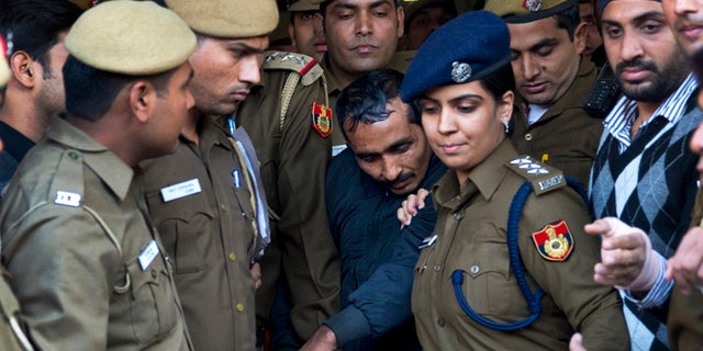 Dec. 8, 2014: Shiv Kumar Yadav, center, a driver from the international taxi-booking service Uber, is surrounded by police as he is brought out after being produced in a court in New Delhi, India.