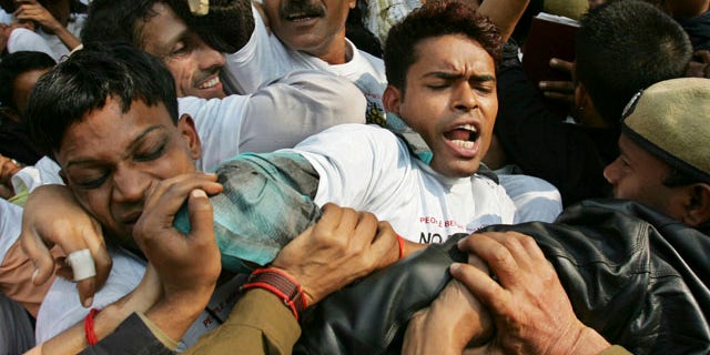 FILE: Indian police officers block demonstrators protesting against drug manufacturer Novartis' case against Indian government on drug patents in New Delhi, India.