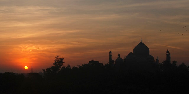File photo - A partial solar eclipse is seen behind the Taj Mahal in the northern Indian city of Agra July 22, 2009.