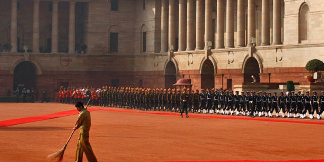 Monday: A barefoot Indian worker sweeps the red carpet before the arrival of U.S. President Obama to a ceremonial reception at Rashtrapati Bhavan, the Presidential Palace in New Delhi, India.