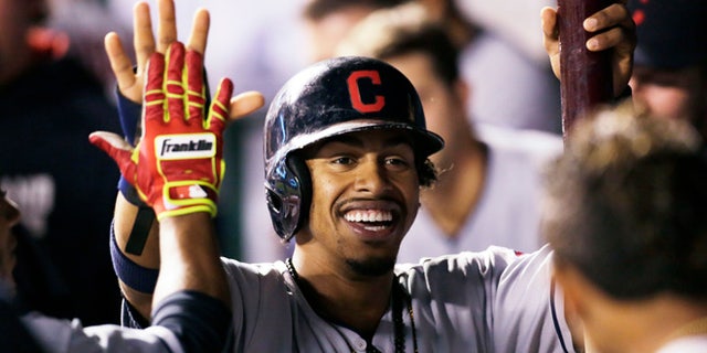 FILE - In this Sept. 30, 2016, file photo, Cleveland Indians' Francisco Lindor is congratulated in the dugout after scoring during the third inning of a baseball game against the Kansas City Royals at Kauffman Stadium in Kansas City, Mo. While most of America gushes over the Chicago Cubs and their quest at ending a 108-year World Series drought, Cleveland's taking aim at its own championship dryspell following a season in which the Indians overcame numerous obstacles and outclassed the AL Central. (AP Photo/Colin E. Braley, File)