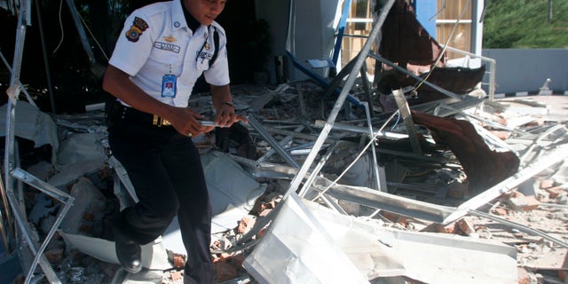 April 12, 2012: A security officer walks through debris from Wednesday's strong earthquake at an office building in Banda Aceh, Aceh province, Sumatra island, Indonesia, Thursday.