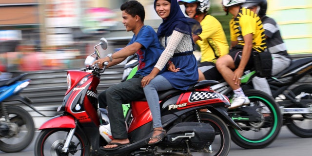 Jan. 7, 2013 - An Acehnese woman straddles on a motorbike on a road in Lhokseumawe, Aceh province, Indonesia.