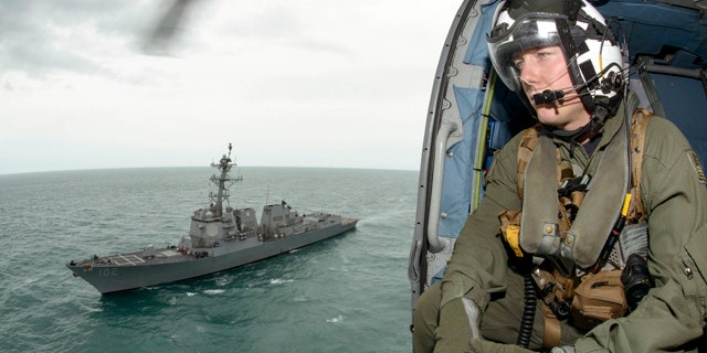 Jan. 6, 2015: Naval aircrewman 2nd Class Cody Witherspoon helps in the search for missing AirAsia Flight 8501 in the Java Sea, as his helicopter returns to the USS Sampson. (AP Photo/U.S. Navy, Petty Officer 1st Class Brett Cote)