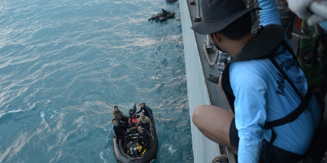 Jan. 9, 2015: Indonesian navy divers prepare operations to lift the tail of AirAsia Flight 8501 in the Java Sea. (AP Photo/Adek Berry, Pool)