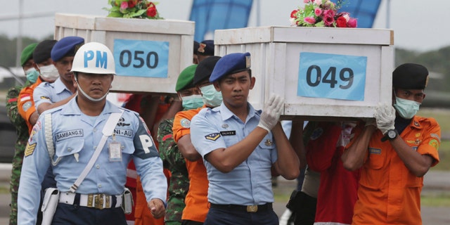 Jan. 19, 2015: Mmbers of the National Search and Rescue Agency carry coffins containing bodies of the victims aboard AirAsia Flight 8501 to transfer to Surabaya at the airport in Pangkalan Bun, Indonesia. (AP Photo/Achmad Ibrahim, File)