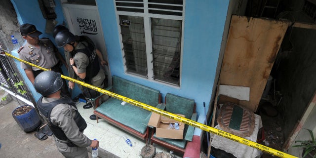 Oct. 27, 2012: Indonesian police officer stand guard outside the house of a suspected terrorist after a raid in Jakarta, Indonesia.