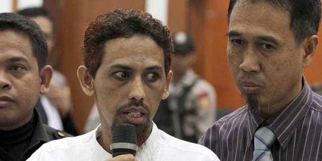 May 7, 2012: Indonesian militant Umar Patek, center, accompanied by his lawyer Ashludin Hatjani, right, speaks to the press during his trial at West Jakarta District Court in Jakarta, Indonesia.