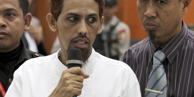 May 7, 2012: Indonesian militant Umar Patek, center, accompanied by his lawyer Ashludin Hatjani, right, speaks to the press during his trial at West Jakarta District Court in Jakarta, Indonesia.