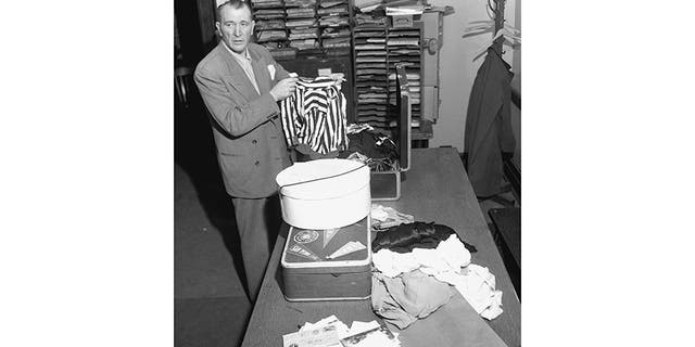 Det. Sgt. Bill Cummings inspects the contents of Elizabeth’s suitcase and hatbox, checked into the Greyhound bus station when she was with Robert “Red” Manley.