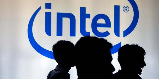 Indonesian youth walk past an Intel sign during Digital Imaging expo in Jakarta March 5, 2014. REUTERS/Beawiharta (INDONESIA - Tags: BUSINESS LOGO SOCIETY) - RTR3G2J1