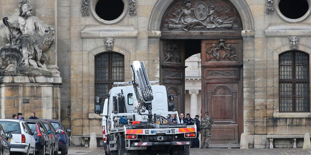 Dec.16, 2015: Police officers and soldiers stand by a heavy wooden door after a car rammed the entrance at France's Invalides monument in Paris. The driver was arrested.
