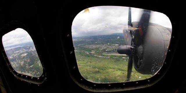 Two of the four engines of a Boeing B-17 "Flying Fortress" bomber are shown through a window May 5, 2014, as it flies near Seattle.